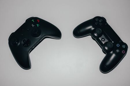 Two game controllers for xbox and playstation on a light backgroundのeditorial素材