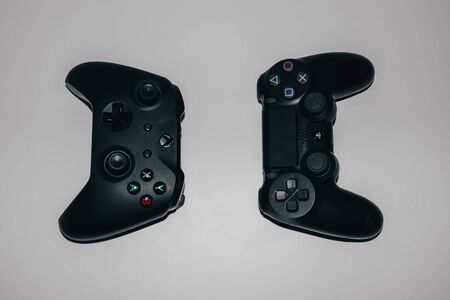 Two game controllers for xbox and playstation on a light backgroundのeditorial素材