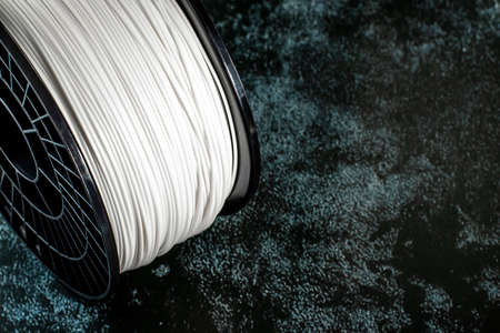Filament for 3d printing. Bright thermoplastic of white color. Reel vertical view. Macro