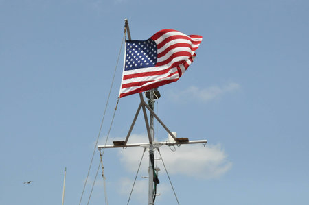 American Flag with a blue sky in backgroundの写真素材