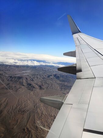 Clouds and sky seen through window of an airplaneの写真素材
