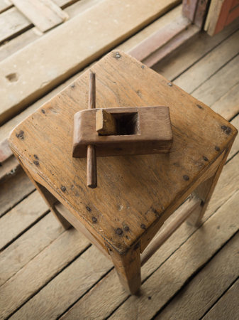 A small asian old plane for wood working placed on a wooden chair in a workshop room.の写真素材