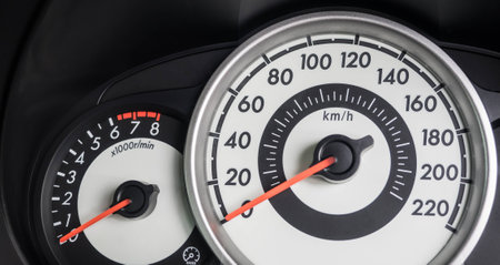 Modern car dashboard with speedo meter/mileage and tachometer in metric.