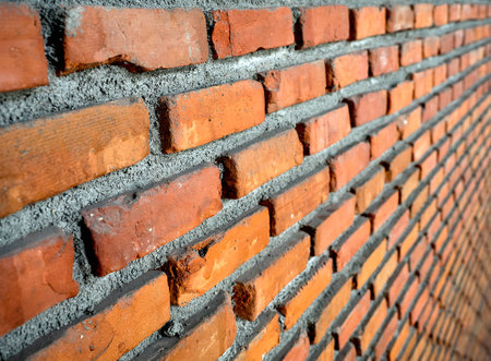 Perspective red brick wall background/texture with cement paste and vignetting effect.