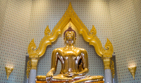 Golden Buddha statue in a temple, Thailand, with a light shining down nicely.の写真素材