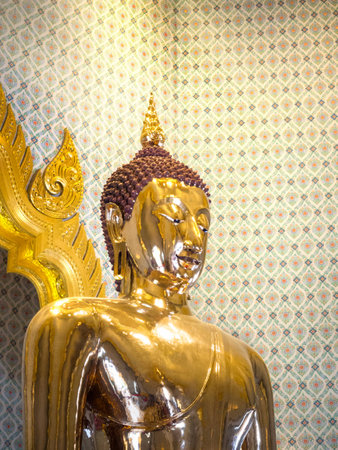 Golden Buddha statue in a temple, Thailand, with a light shining down nicely.の写真素材