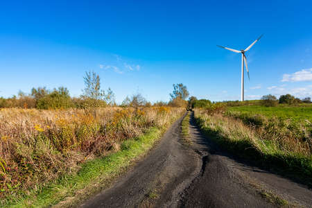 Green meadow with wind turbine generating electricity
