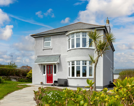 White traditional detached house view with beautiful front gardenの写真素材