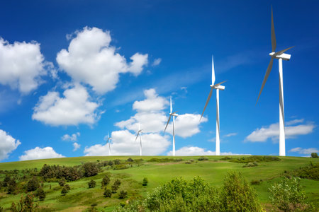 Green hill with wind turbines producing electricityの写真素材