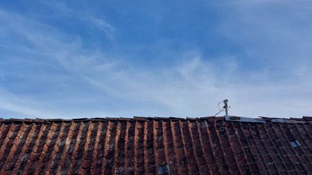 Roof of old house with blue sky and white clouds background.の写真素材