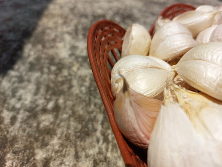 Garlic in a basket on a stone background. Selective focus.