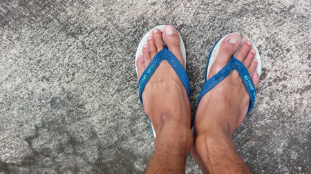 Selfie of male feet with blue measuring tape on concrete floor.の写真素材