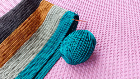 Knitting needles and yarn on pink background. Close up. Selective focus.
