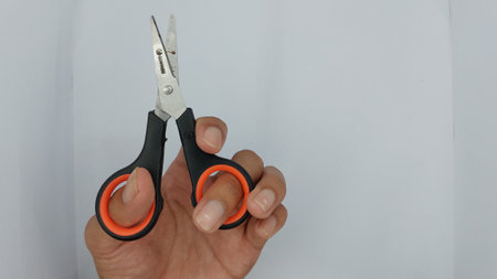 Scissors on a white background. A woman's hand holds scissors.の写真素材
