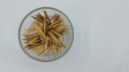 toothpicks in a glass bowl on a white background.の写真素材