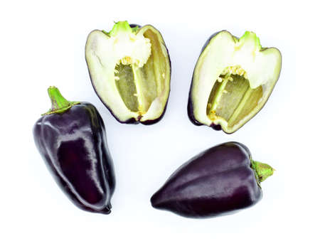 Whole and cut violet bell peppers on white background, top view. The bell pepper, also known as sweet pepper, pepper or capsicum.の写真素材