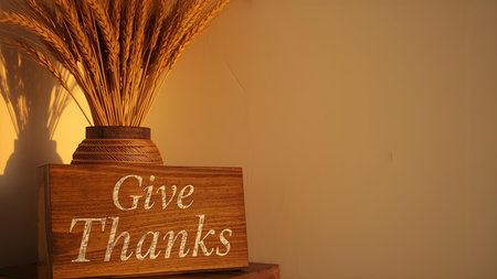 \Wooden signboard with the text \"\"Give thanks\"\" and bunch of wheat ears on the table\""の素材