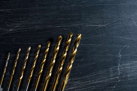 Drill bits on wooden background
