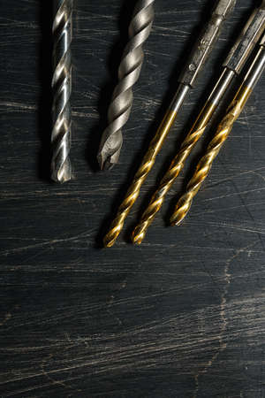 Drill bits on wooden background