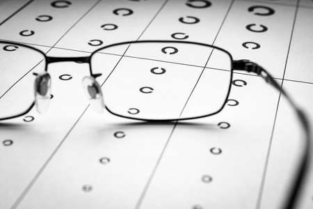 Eyeglasses and visual acuity chart in white background