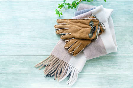 Woolen scarf and gloves on wooden backgroundの写真素材