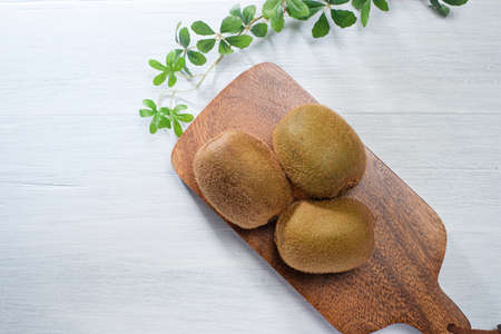 Kiwi fruits and cutting board on wooden table