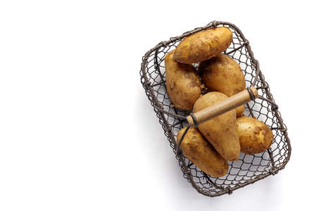 Raw unpeeled potatoes on wooden tableの写真素材