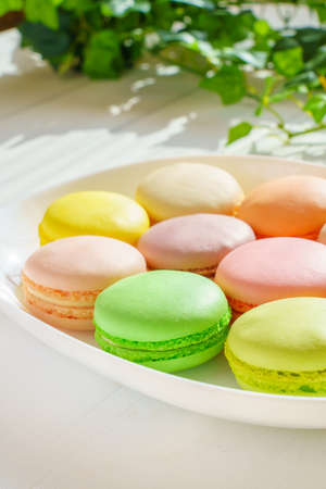 Sweet colorful macaroons on wooden background