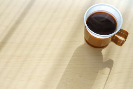 Hot black coffee isolated on wooden table