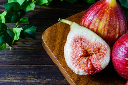 Fresh figs. Fruit with half isolated on wooden background.