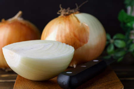 Raw unpeeled onions on wooden tableの写真素材