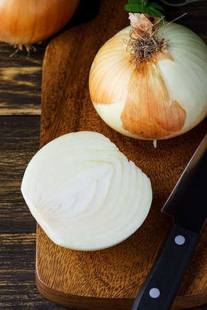 Raw unpeeled onions on wooden tableの写真素材