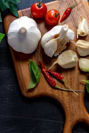 Garlic, tomato and red pepper on wooden table