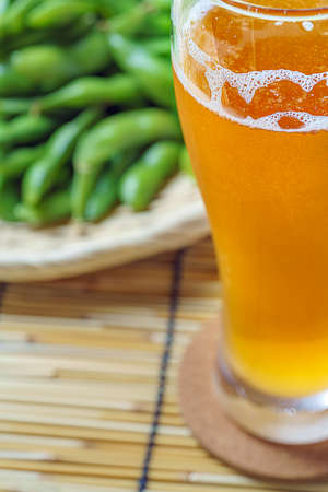 Boiled green soy beans 'Japanese Edamame' and a glass of beerの写真素材
