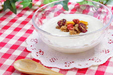 Bowl of fresh yogurt on wooden table