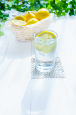 Lemon water in glass isolated on wooden table