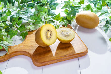 Kiwi fruits and cutting board on wooden table