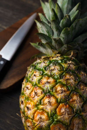 Fresh pineapple and cutting board on wooden tableの写真素材