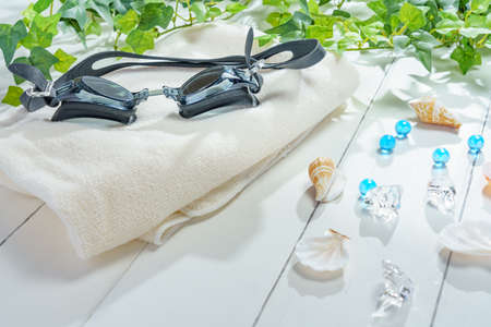 Underwater glasses and towels on wooden tableの写真素材