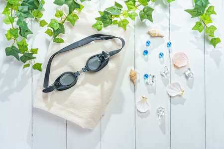 Underwater glasses and towels on wooden tableの写真素材