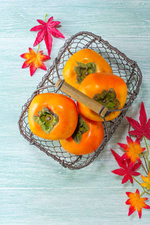 Fresh ripe persimmons on wooden tableの写真素材