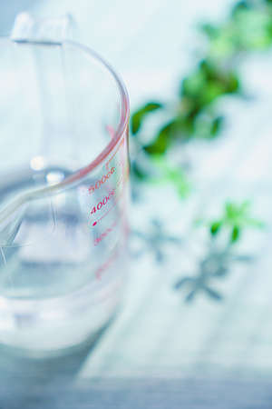 Measuring cup isolated on wooden tableの写真素材