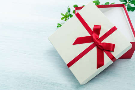 Gift box with ribbon on wooden table