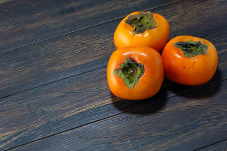 Fresh ripe persimmons on wooden tableの写真素材