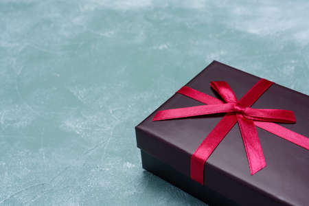 Gift box with ribbon on wooden table