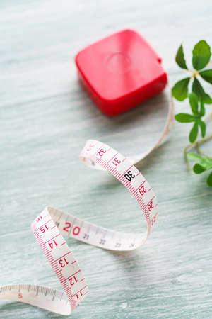 White measuring tape isolated on wooden table