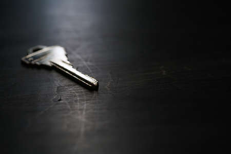 Silver house key on wooden tableの写真素材
