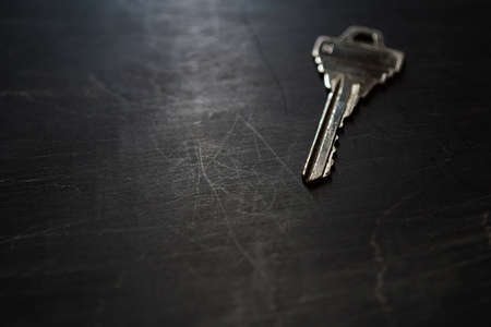 Silver house key on wooden tableの写真素材