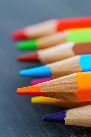 Colored pencils on wooden background