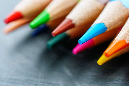 Colored pencils on wooden background